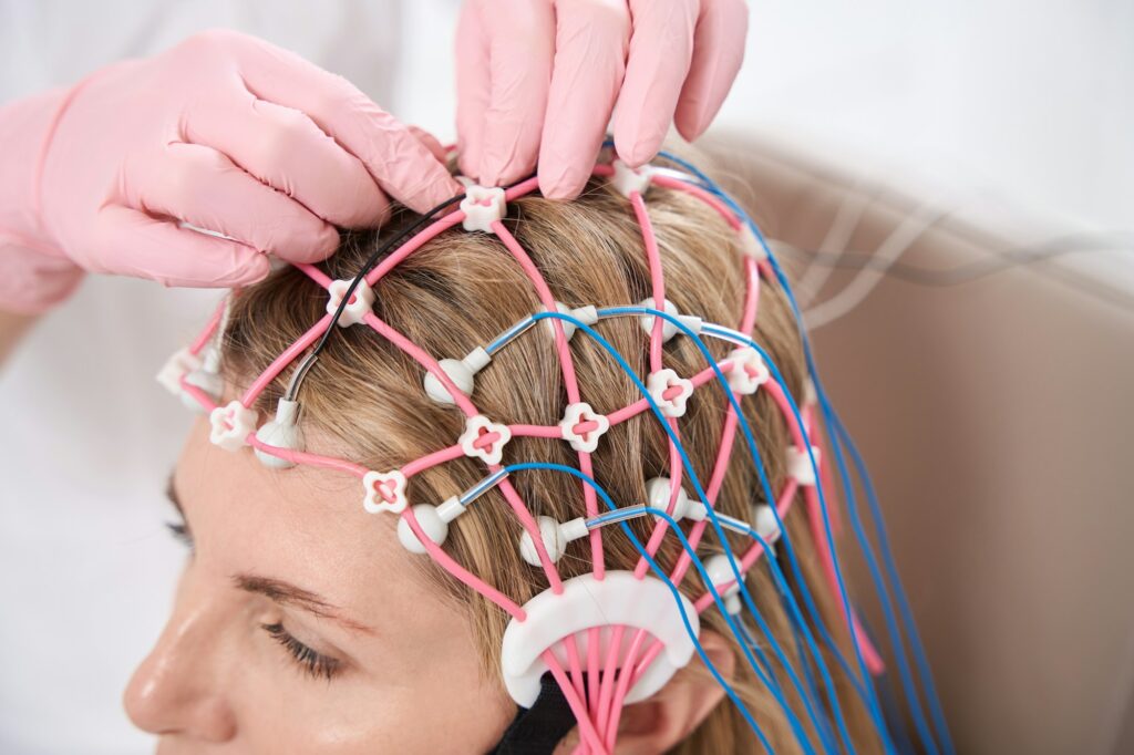 Doctor attaches cap with electrodes patients head for diagnostic procedure