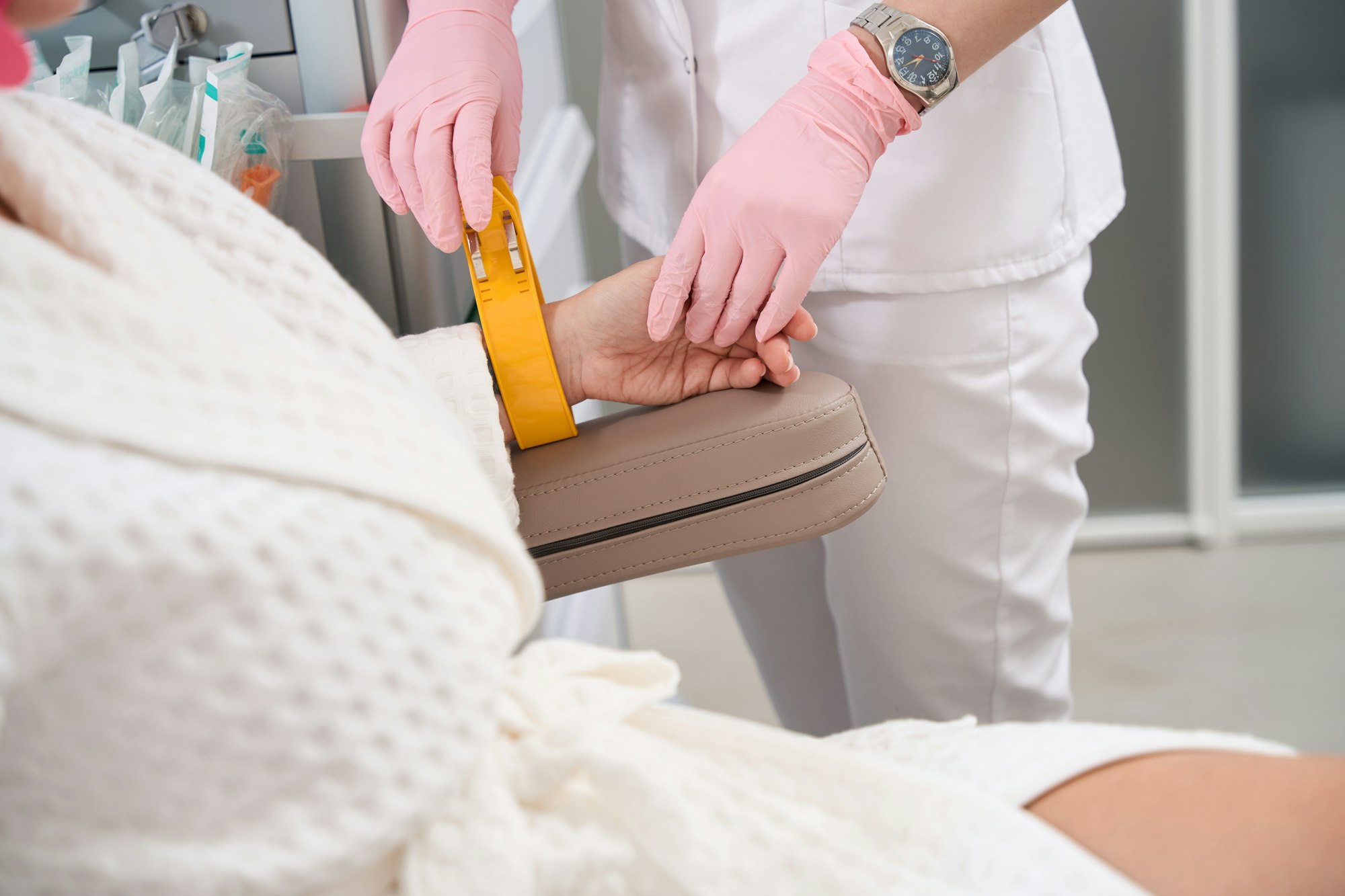 Doctor attaches electrodes to the patients hand for diagnostic procedure