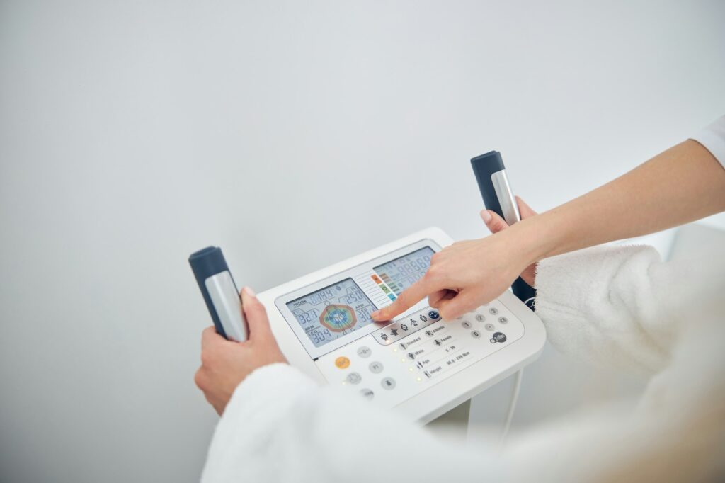 Female hand while turning the program of the segmental body analyzer