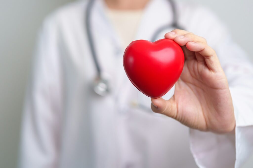 Doctor hand holding red heart shape in hospital