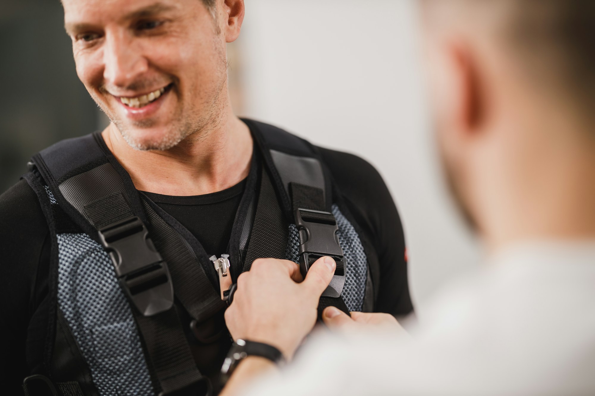 Fitness Instructor Putting An Ems Suit To A Man