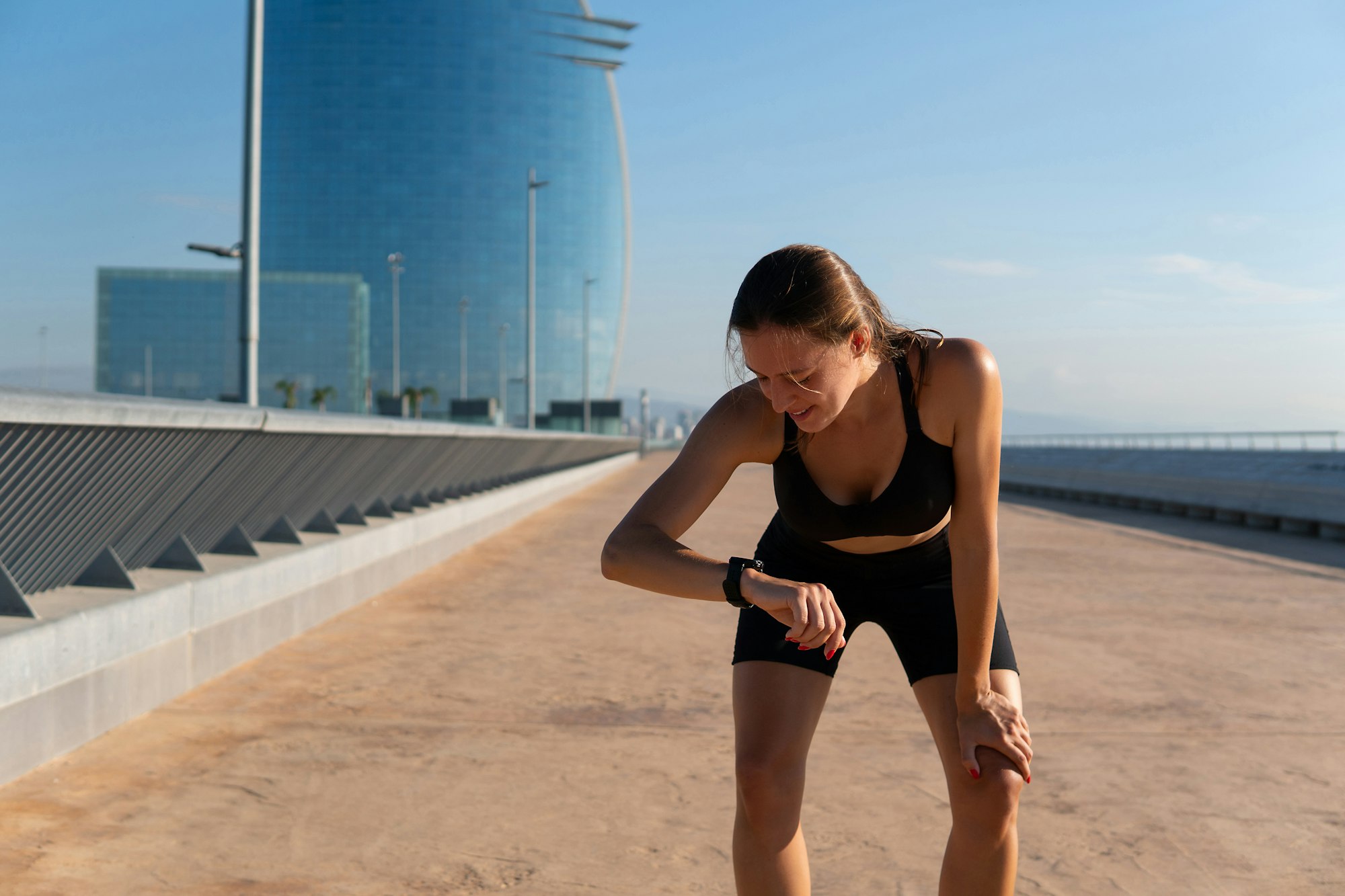 Glad sportswoman checking smart watch