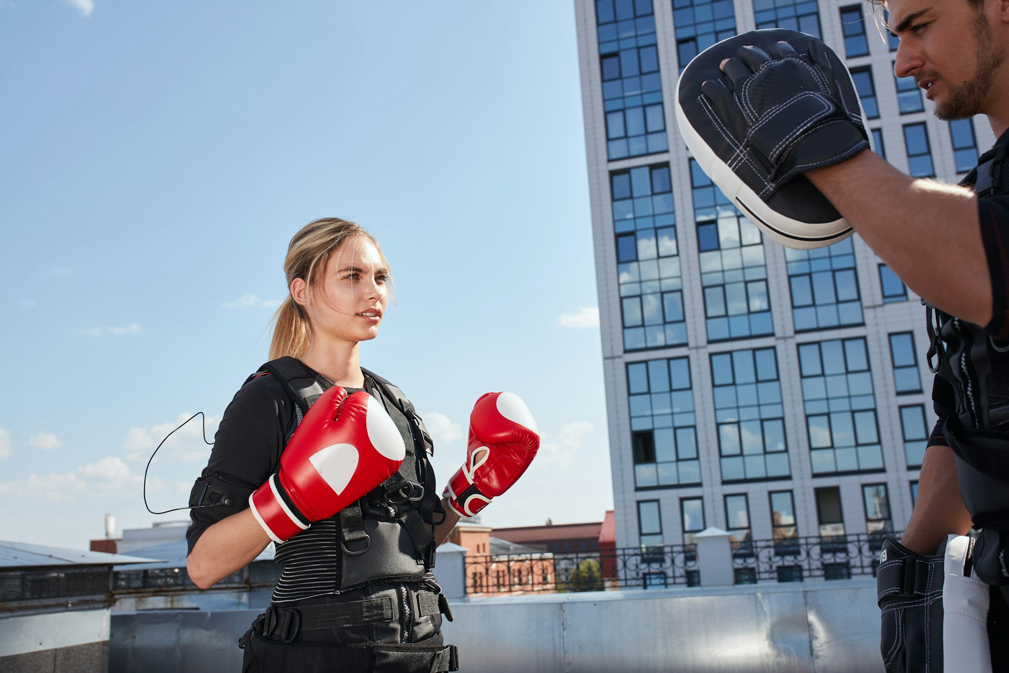 beautiful blonde working out with boxing gloves and ems suit